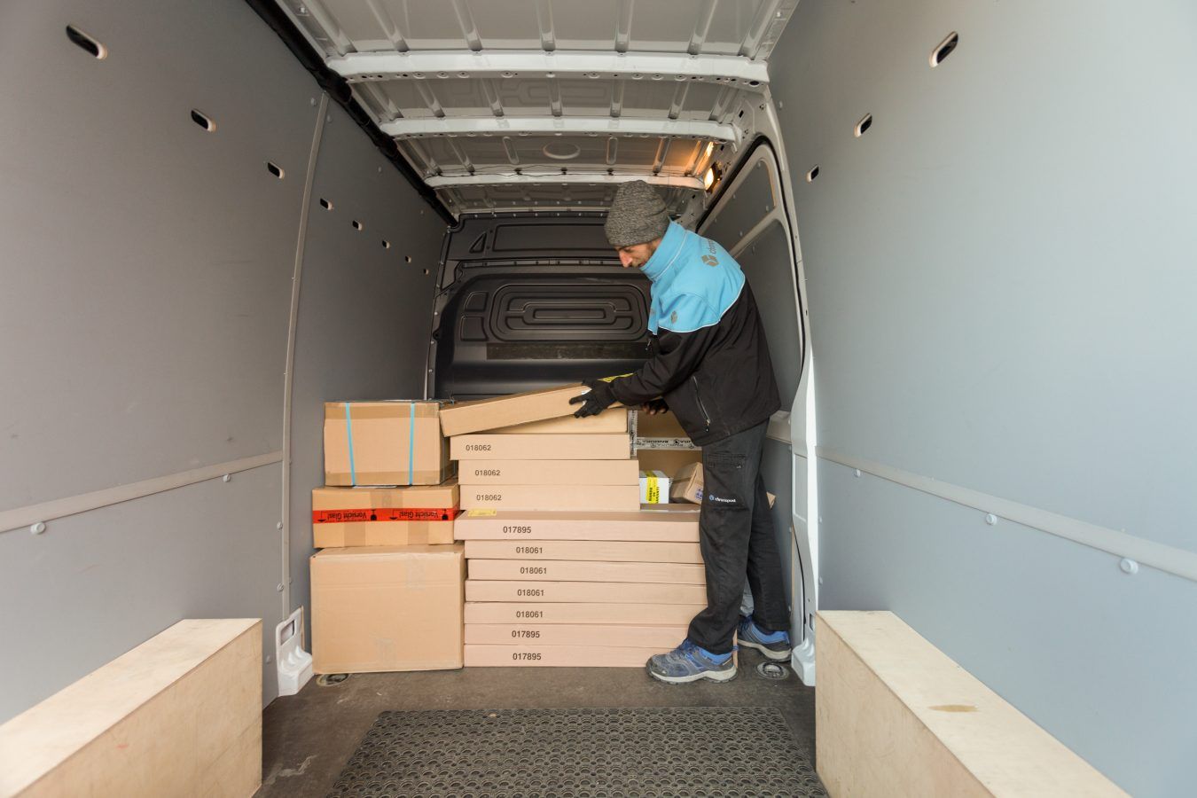 Une personne charge des cartons empilés à l'arrière d'un camion de déménagement