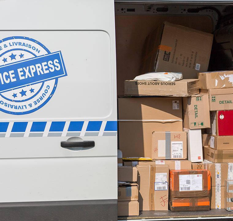 Camionnette de livraison chargée de cartons et de colis empilés dans la zone de chargement
