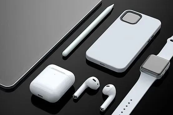 Un teléfono, auriculares, un reloj y un lápiz sobre una mesa.