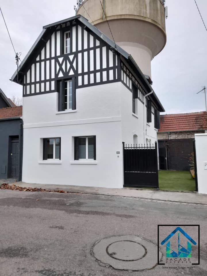 Maison à colombages avec château d'eau derrière