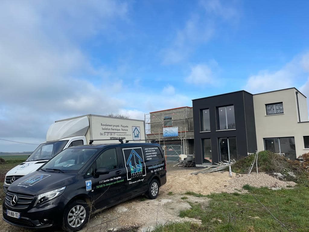 Voiture noire devant construction de maison