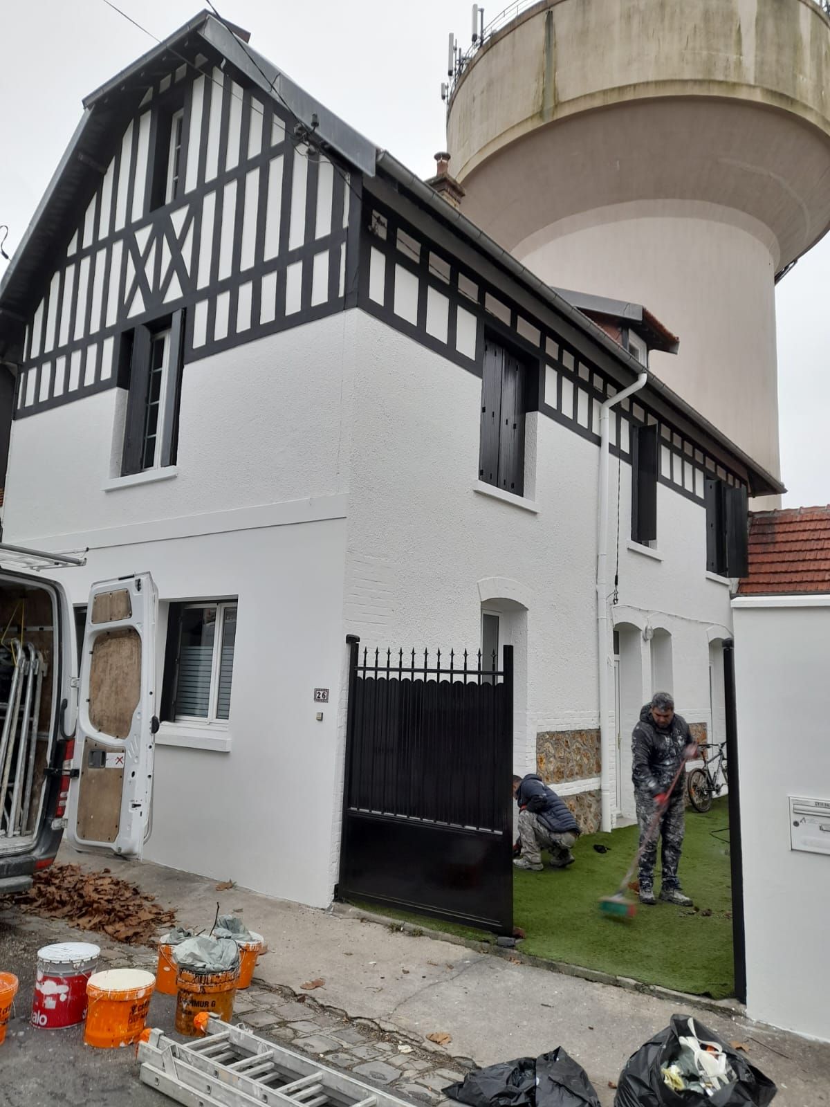 Clôture noire en fer devant une maison blanche