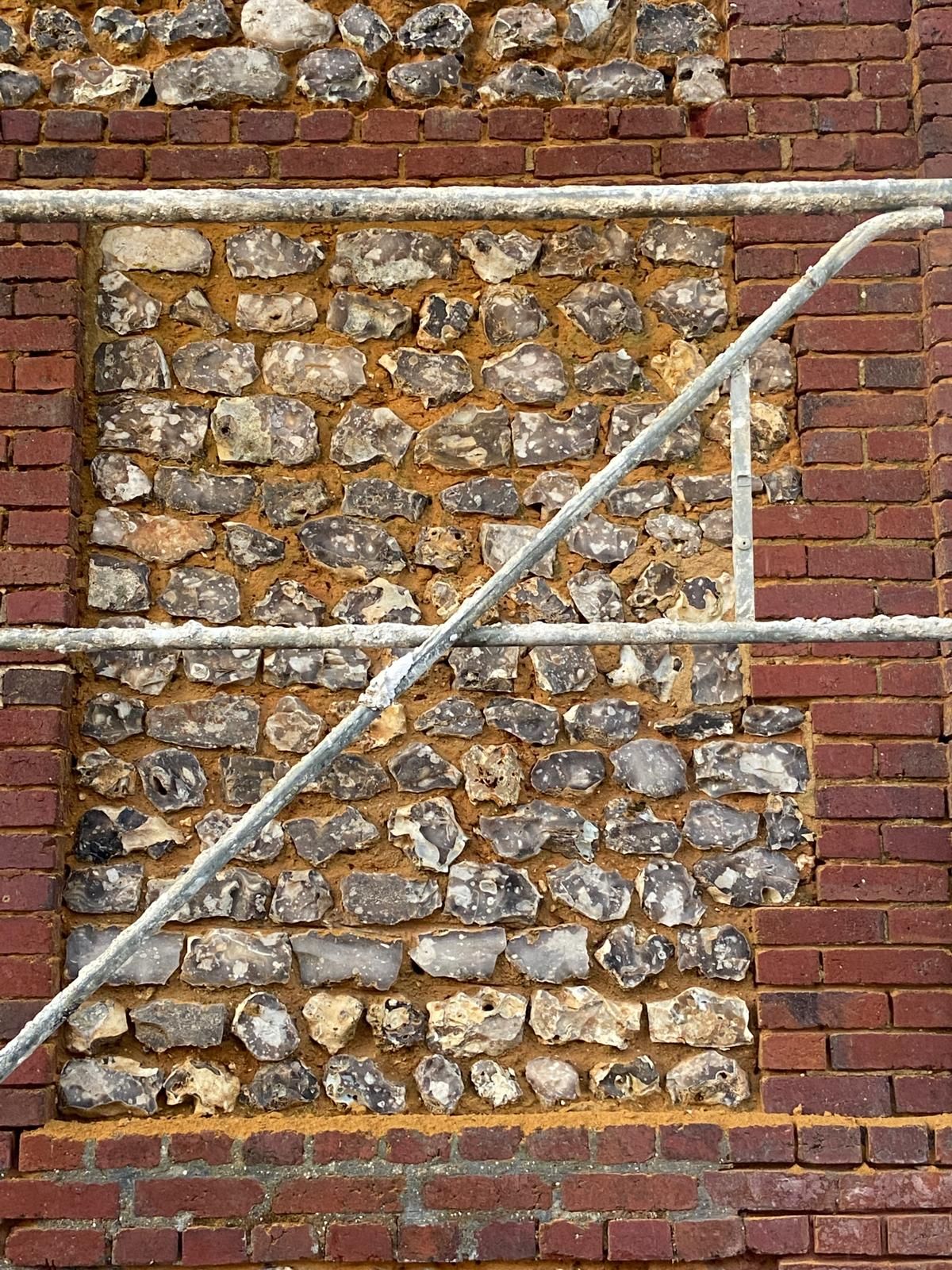 Mur de pierres, briques et silex