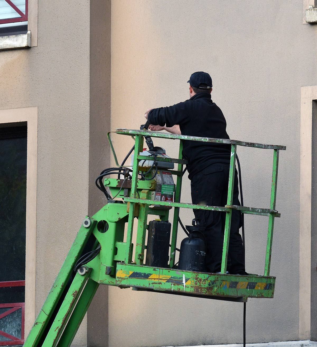 Nettoyage d'une façade sur une nacelle verte