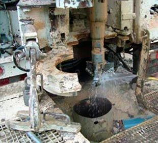 Una máquina está perforando un agujero en el suelo del que sale agua.