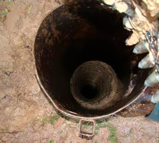 Un primer plano de un cubo de metal con un agujero en el medio.