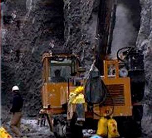 Un hombre está parado junto a un tractor en una cueva.