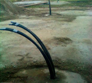 Dos tubos negros sobresalen de un agujero en el suelo.