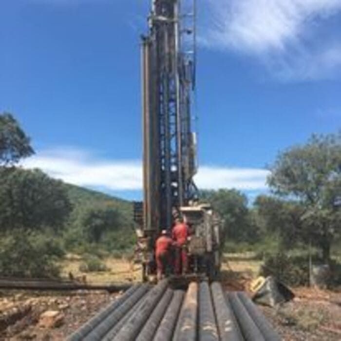 Un grupo de personas está trabajando en una máquina grande en un campo.