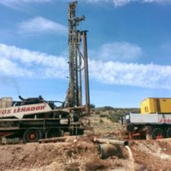 Un camión con la palabra Lenador en él circula por un camino de tierra.