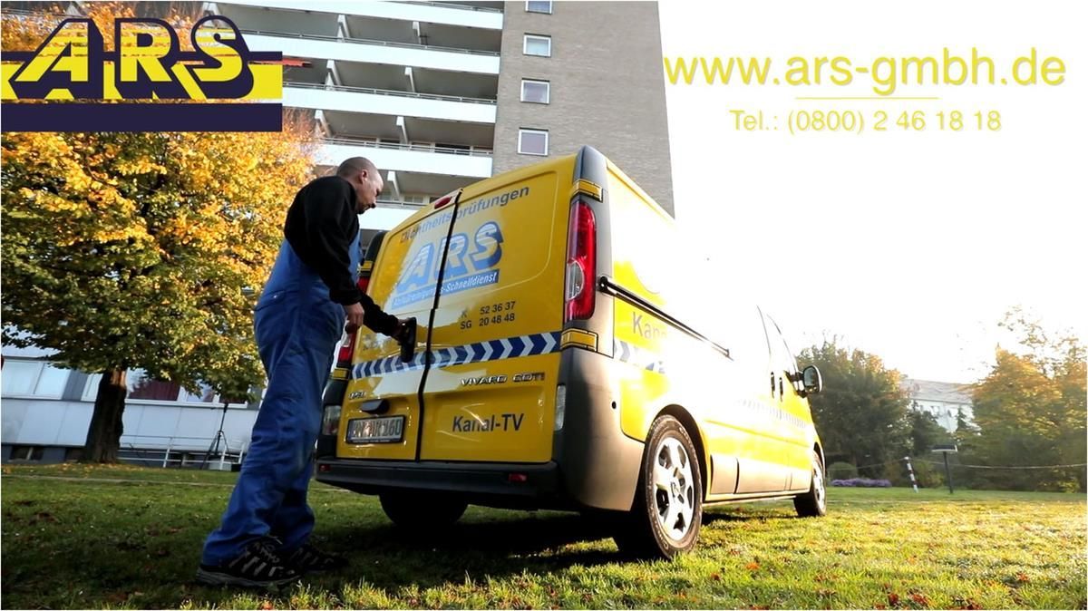 Ein Mann steht neben einem gelben Ars Van