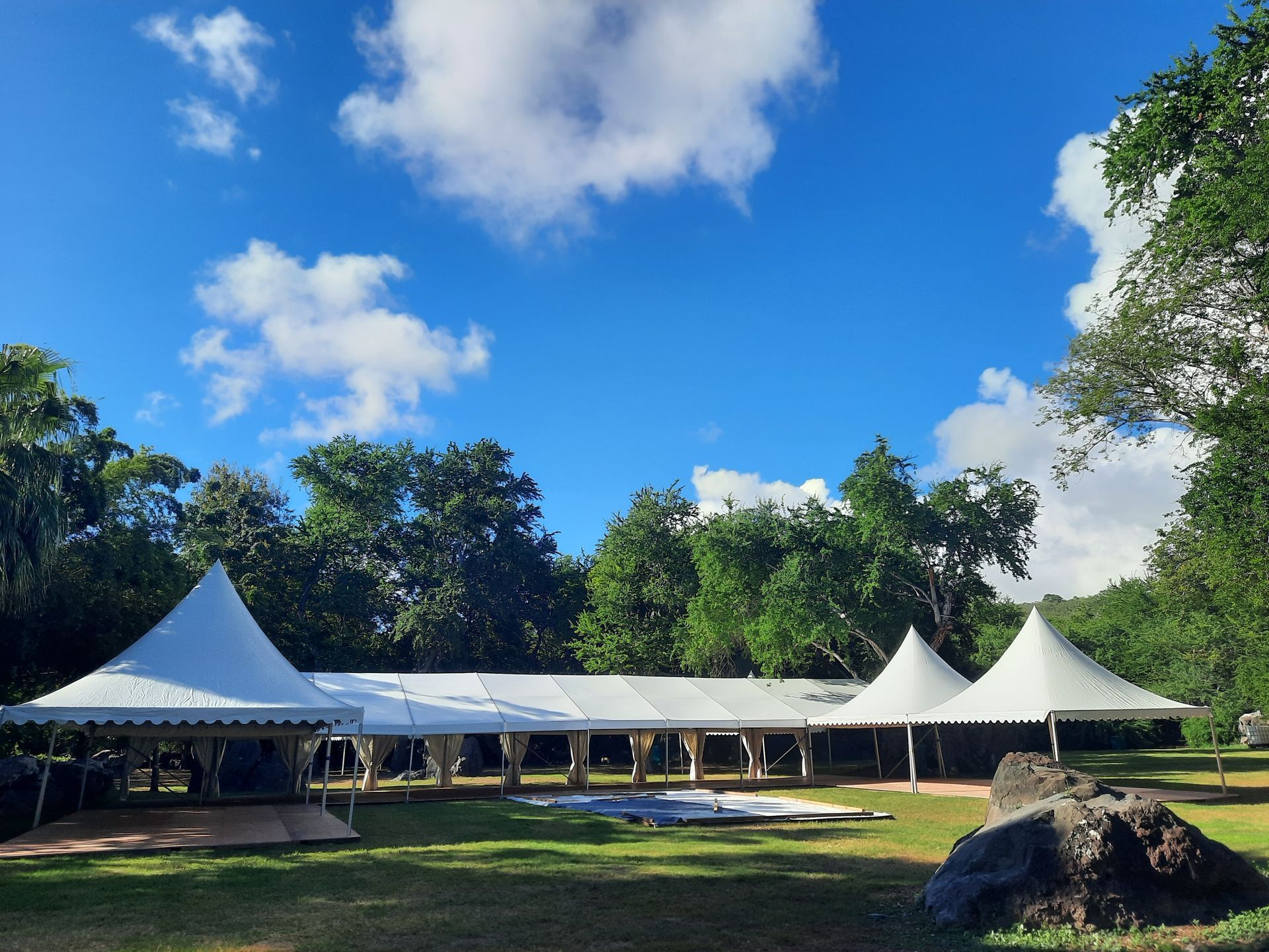 Tente de réception blanche avec plancher sur une pelouse.