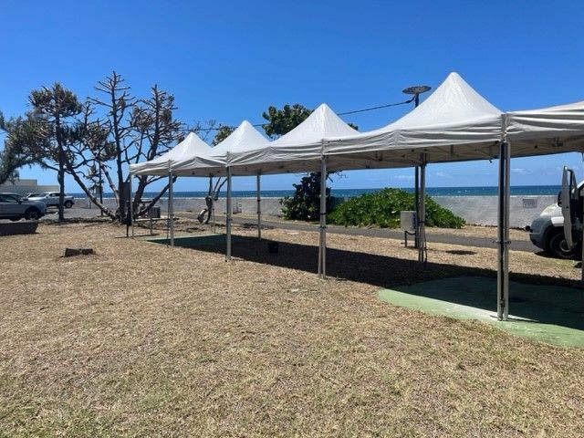 Tente de réception pliable blanche avec vue sur l'océan.