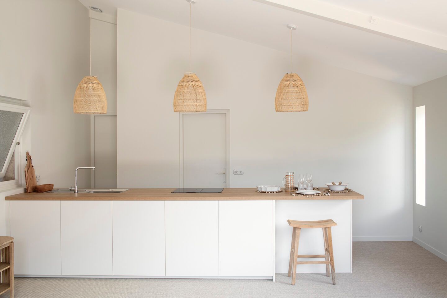 Une cuisine avec trois luminaires en osier.