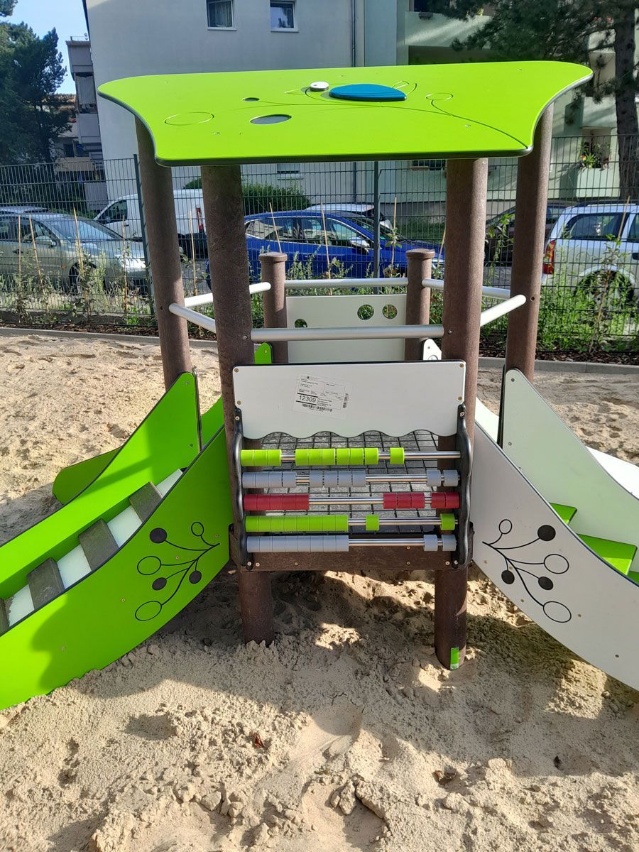 ein Holzgebäude mit einem Zaun davor und einem Traktor dahinter - Spielplatzprüfung Franziska Müller aus Lüchow im Wendland