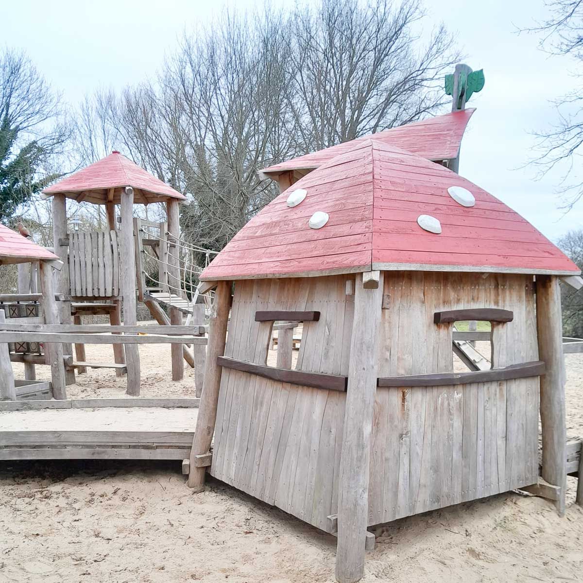 ein Holzgebäude mit einem Zaun davor und einem Traktor dahinter - Spielplatzprüfung Franziska Müller aus Lüchow im Wendland