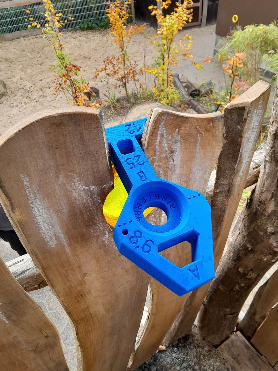 eine blaue und gelbe Maschine , die auf einem Holzstück sitzt - Spielplatzprüfung Franziska Müller aus Lüchow im Wendland