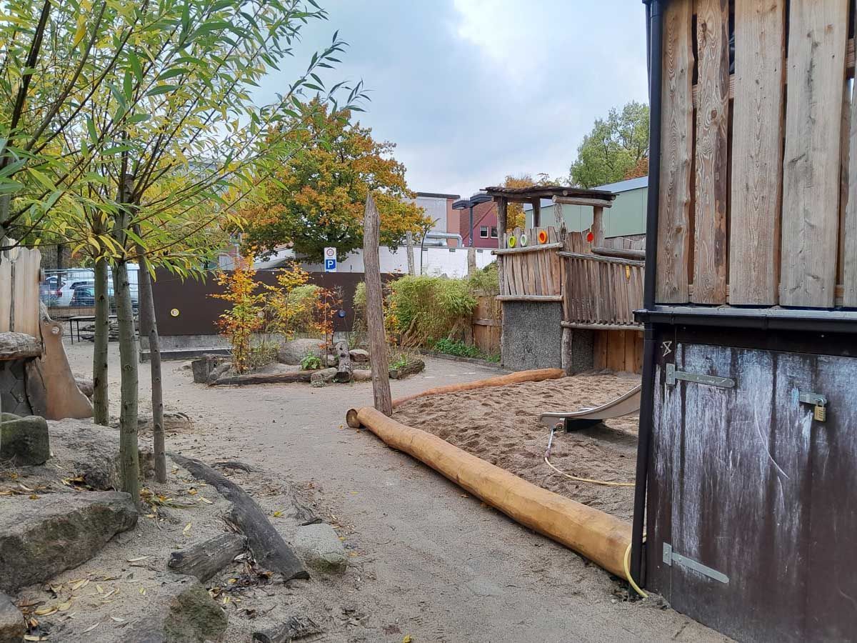 ein Holzgebäude mit einem Spielplatz dahinter - Spielplatzprüfung Franziska Müller aus Lüchow im Wendland