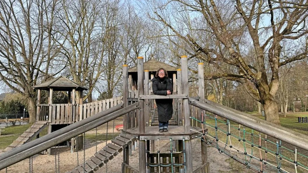 ein Holzgebäude mit einem Zaun davor und einem Traktor dahinter - Spielplatzprüfung Franziska Müller aus Lüchow im Wendland