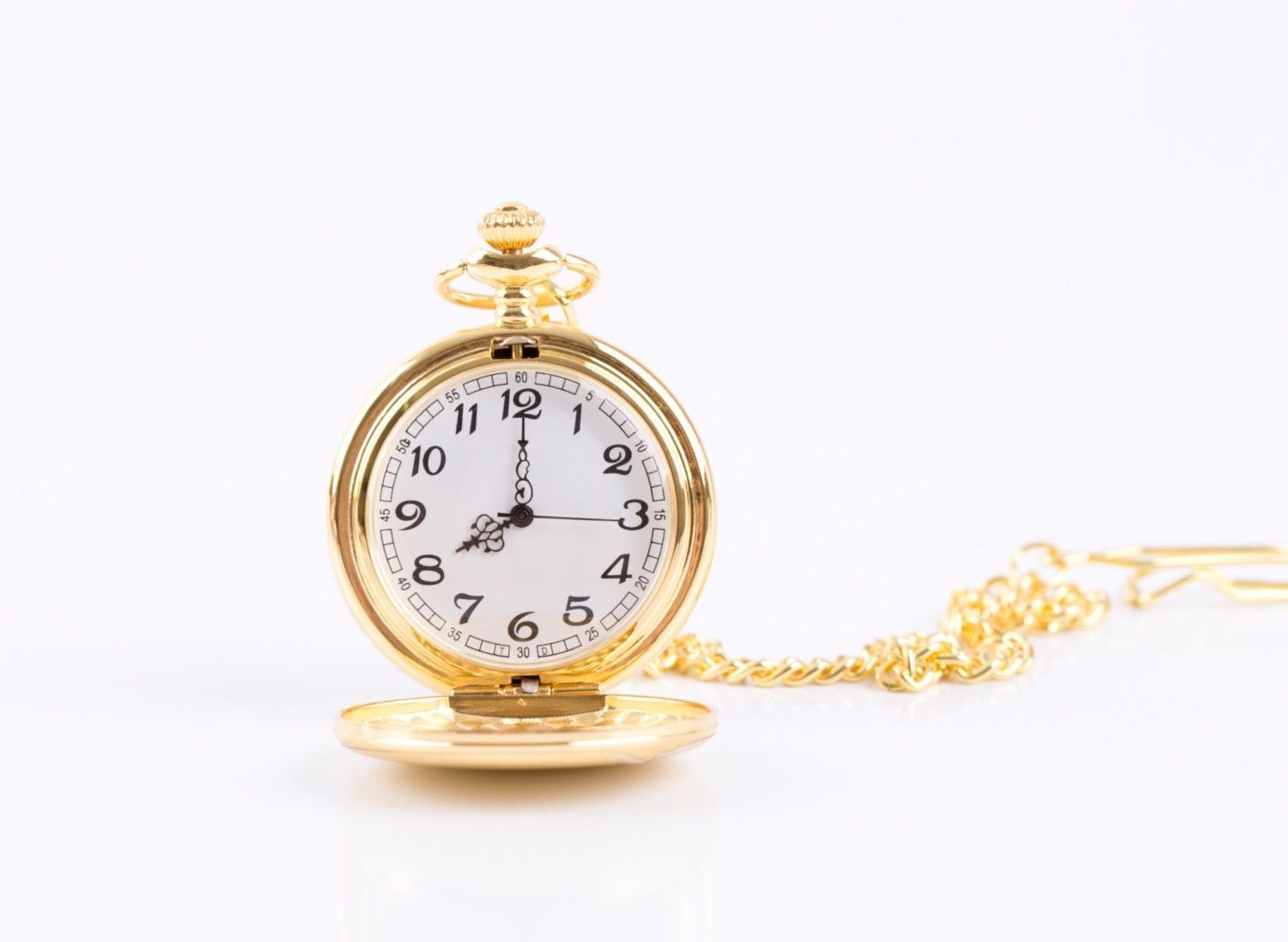 Reloj de bolsillo dorado abierto, sobre fondo blanco, con cadena dorada.