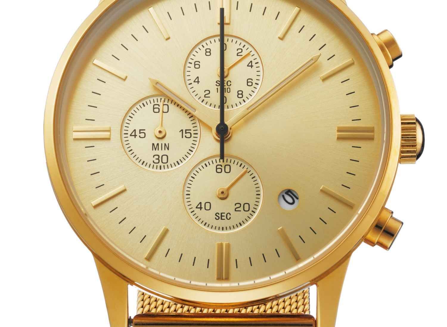 Reloj cronógrafo en tono dorado con tres subesferas y correa de malla, sobre fondo blanco.