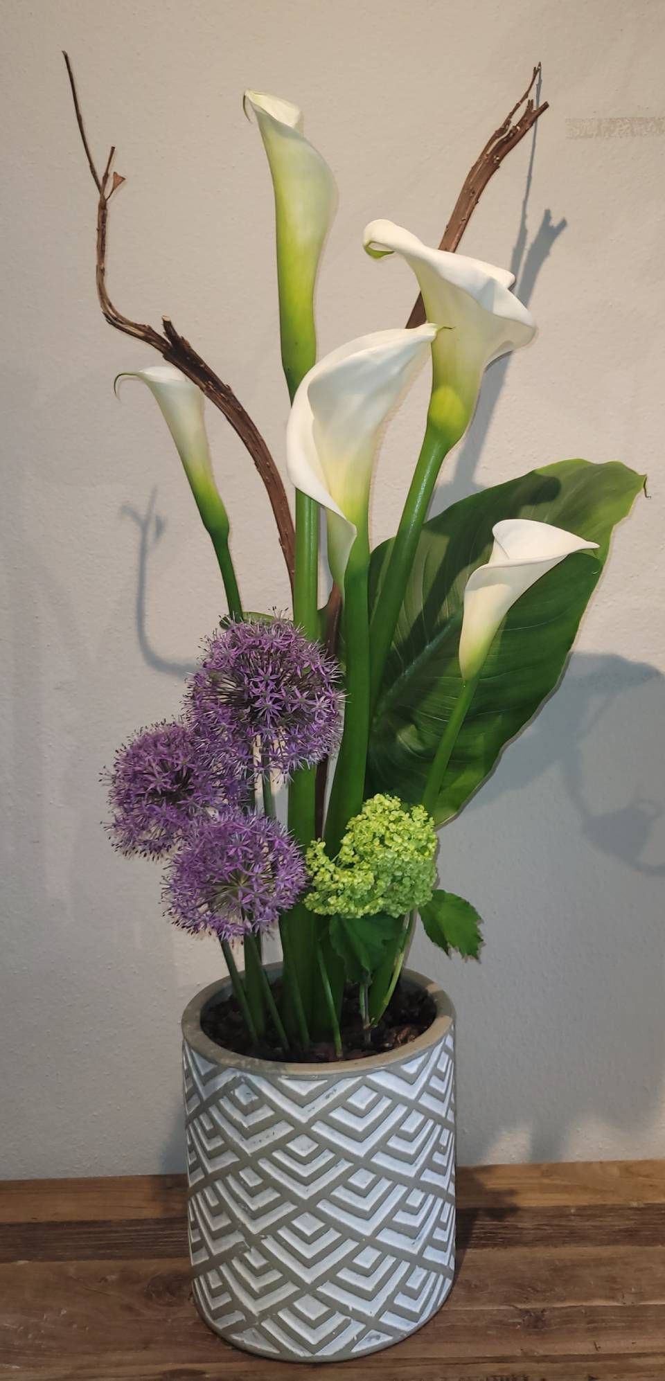 Un vase rempli de fleurs est posé sur une table en bois.