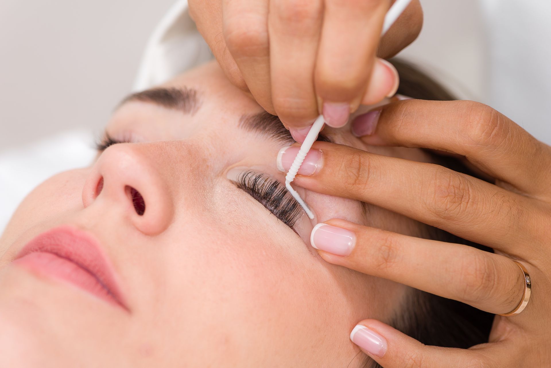 Una mujer se está arreglando las pestañas en un salón de belleza.