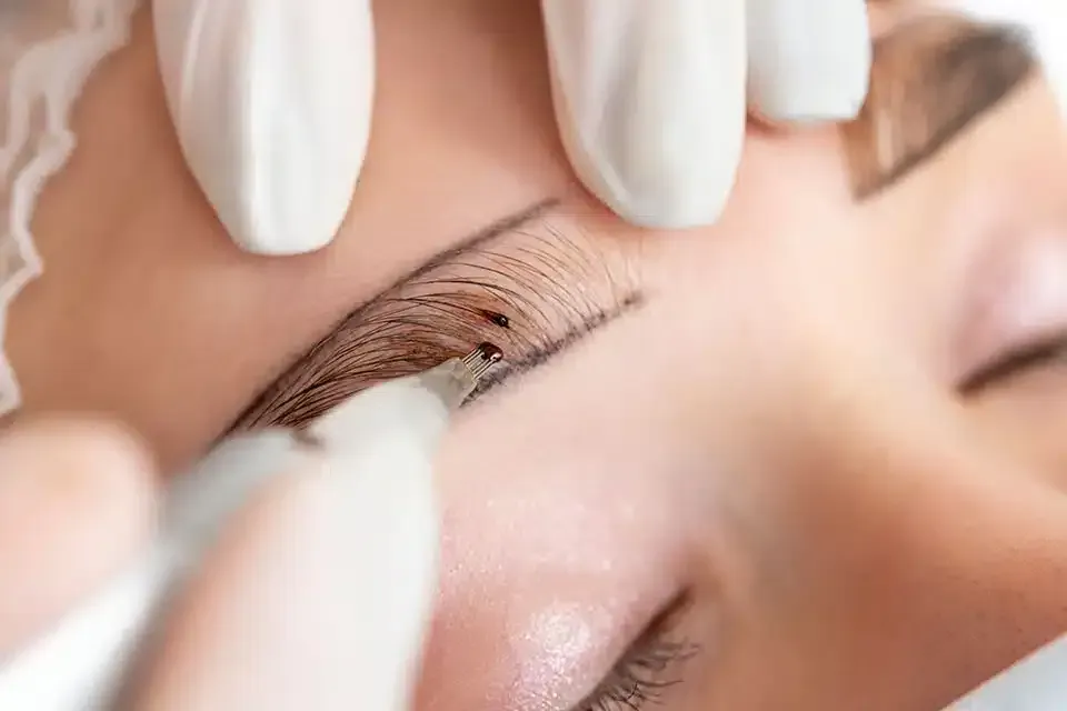 Una mujer se está haciendo un levantamiento de pestañas en un salón de belleza.