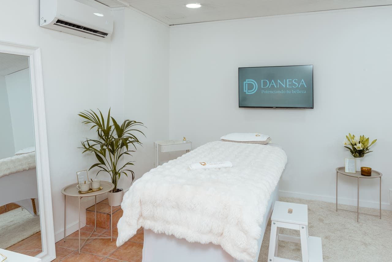 Una mesa de masajes en una habitación con un televisor en la pared.