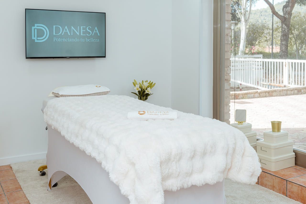 Una mesa de masajes en una habitación con un televisor en la pared.