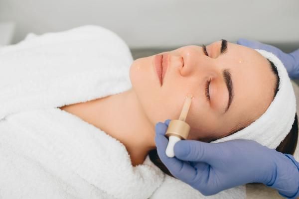 Una mujer está recibiendo un tratamiento facial en un spa.