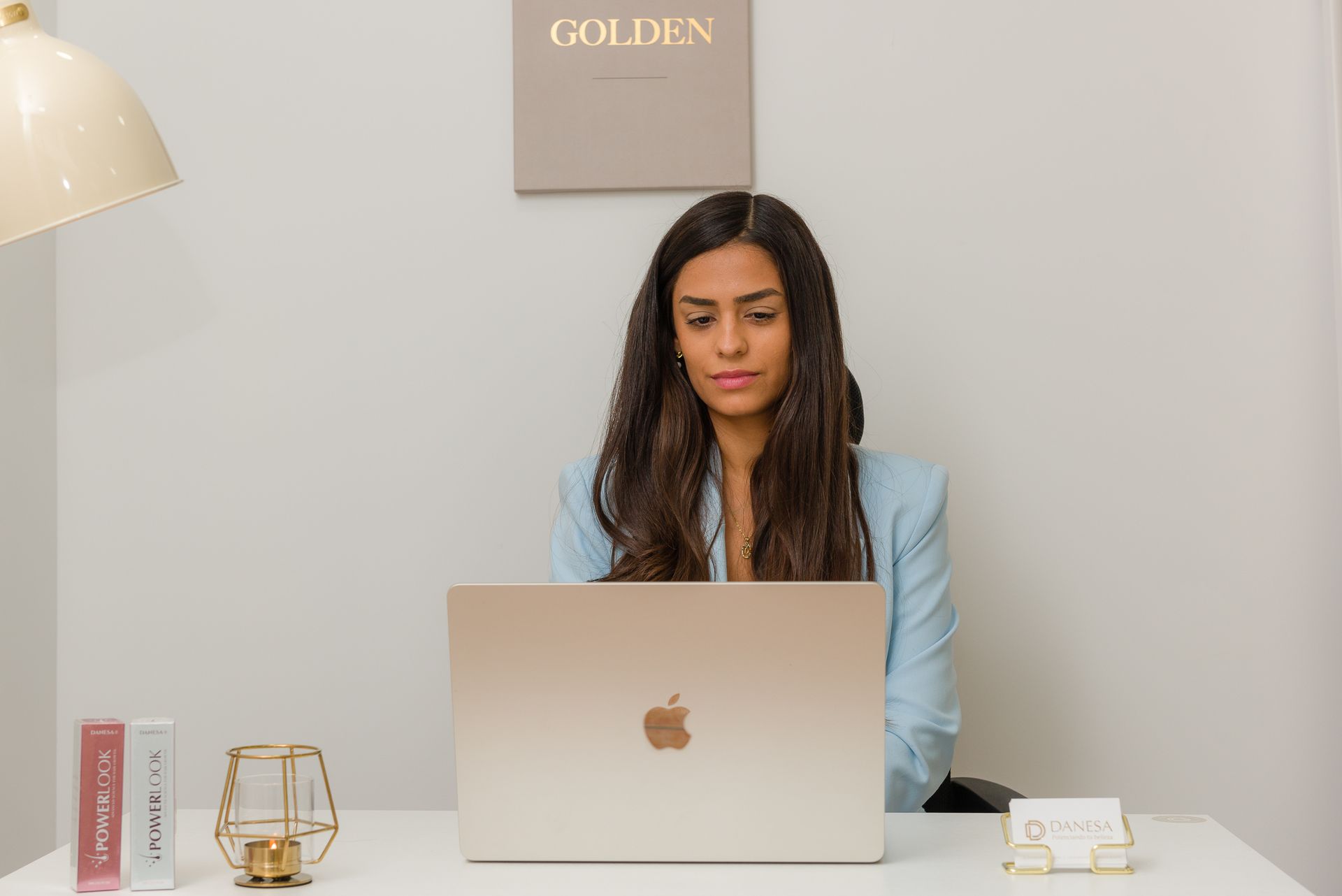 Una mujer está sentada en un escritorio utilizando una computadora portátil.