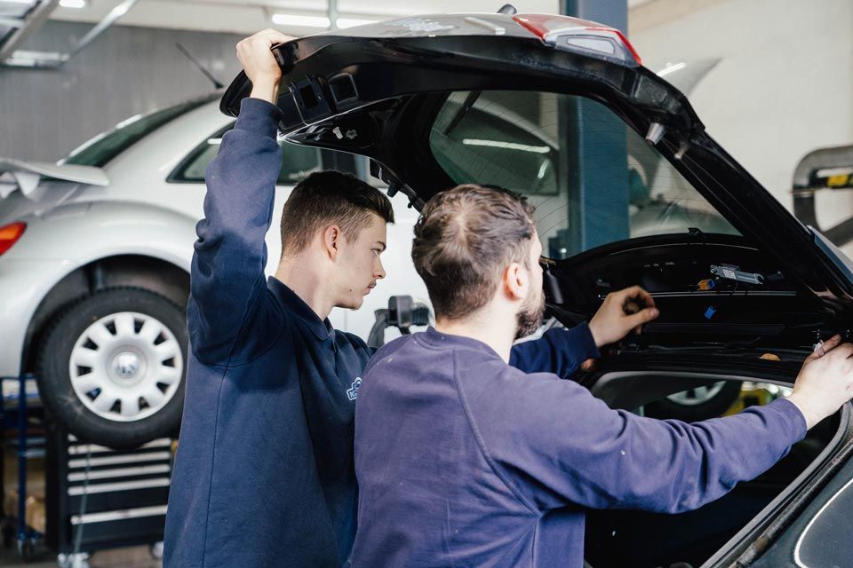 Mitarbeiter von Karosserie Geiger arbeiten an einem Auto