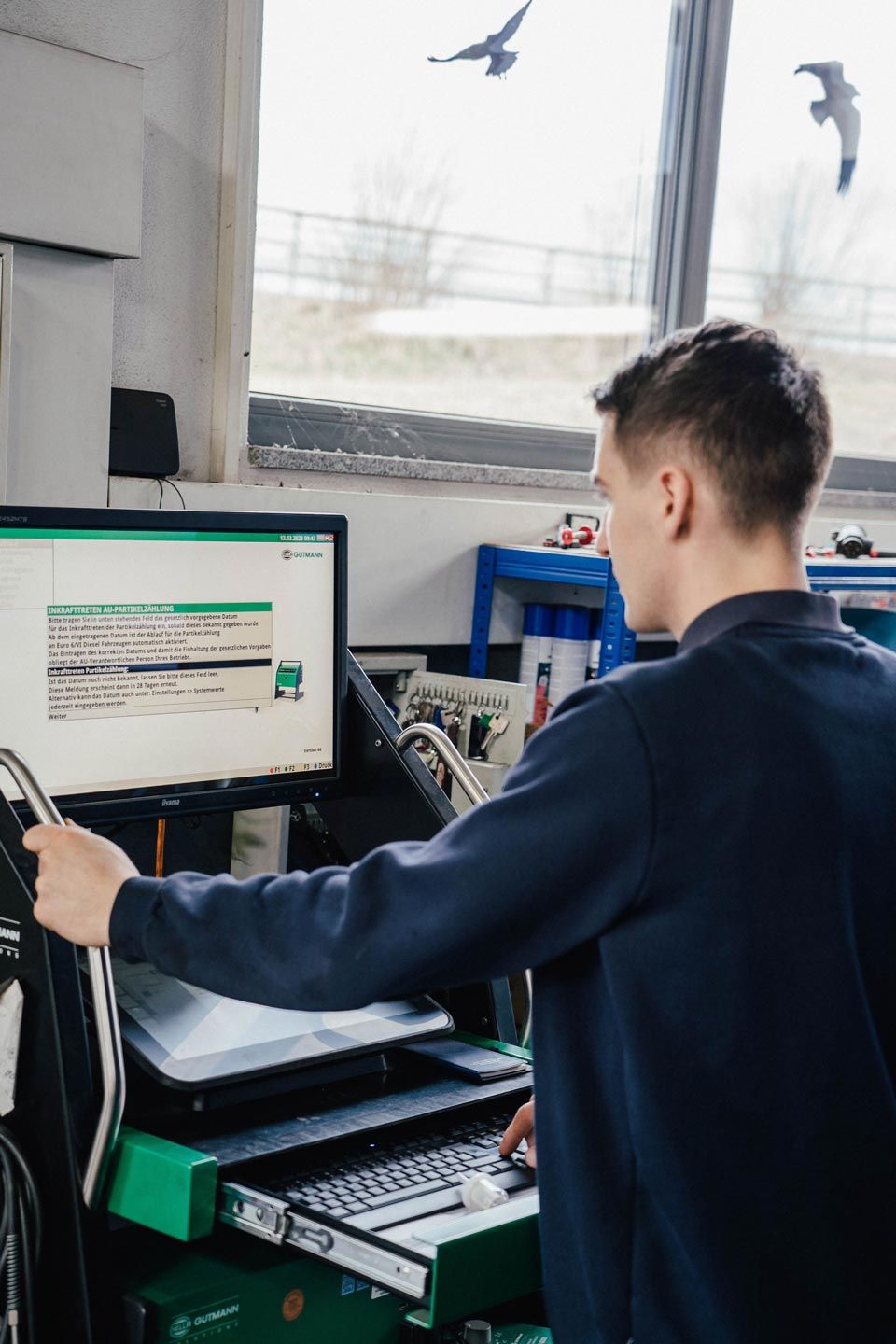 Ein Mitarbeiter von Karosserie Geiger analysiert am Computer das Auto