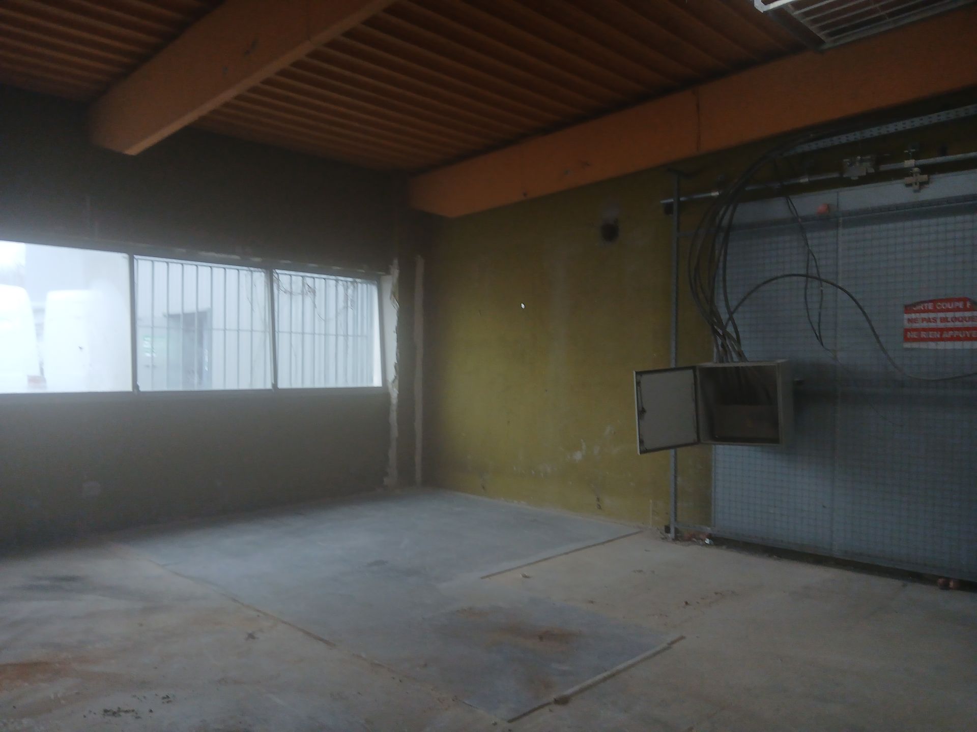 Un intérieur industriel vide avec une fenêtre avec les cloisons en placo enlevé et avec une  pièce nettoyée. Ceci est après l'intervention du professionnel.