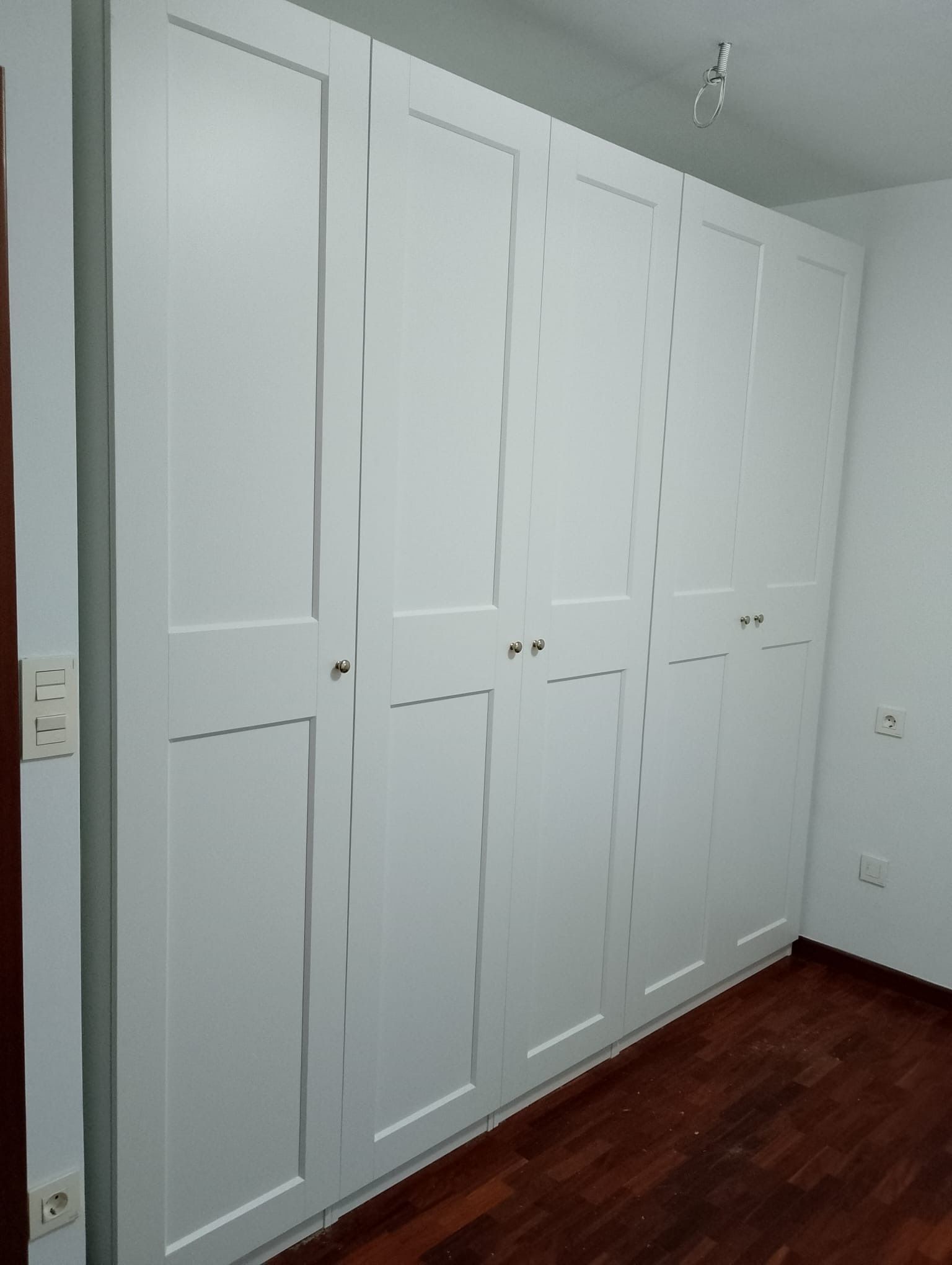 El interior de un armario blanco con la puerta abierta.