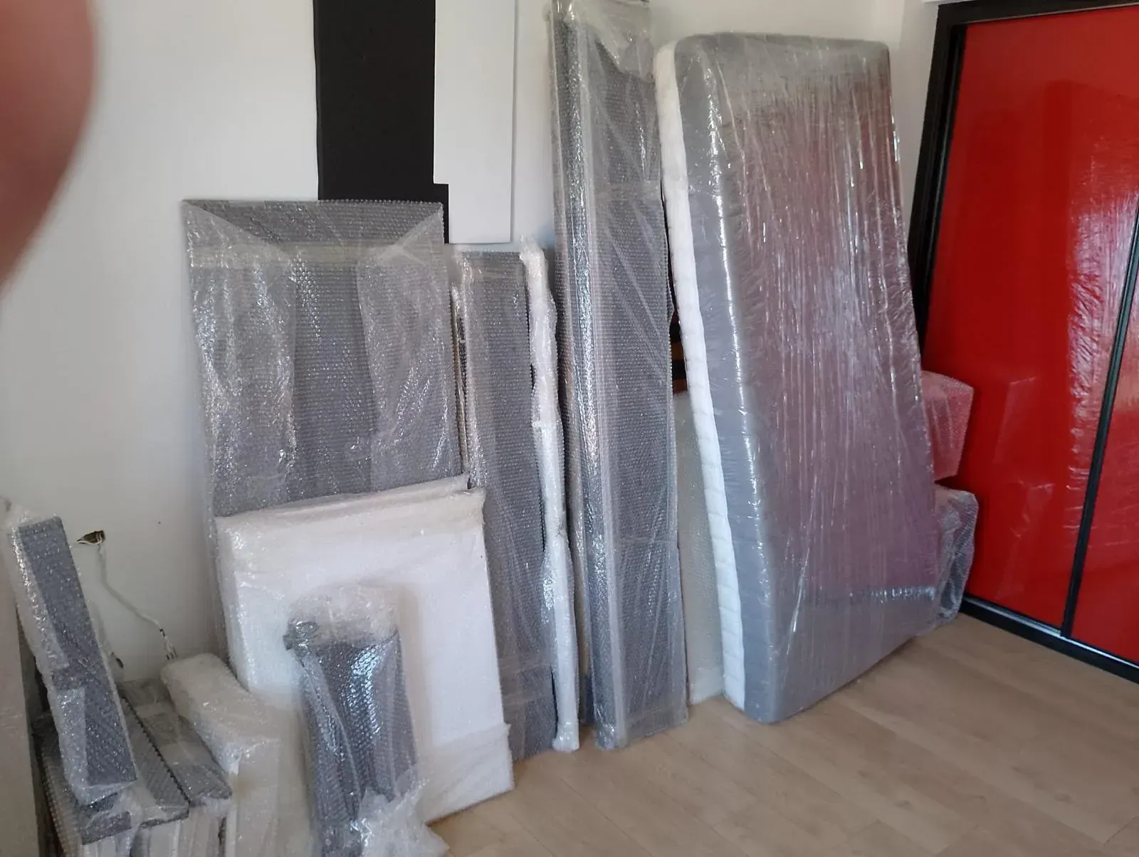 Una habitación llena de muebles envueltos en plástico y plástico de burbujas.