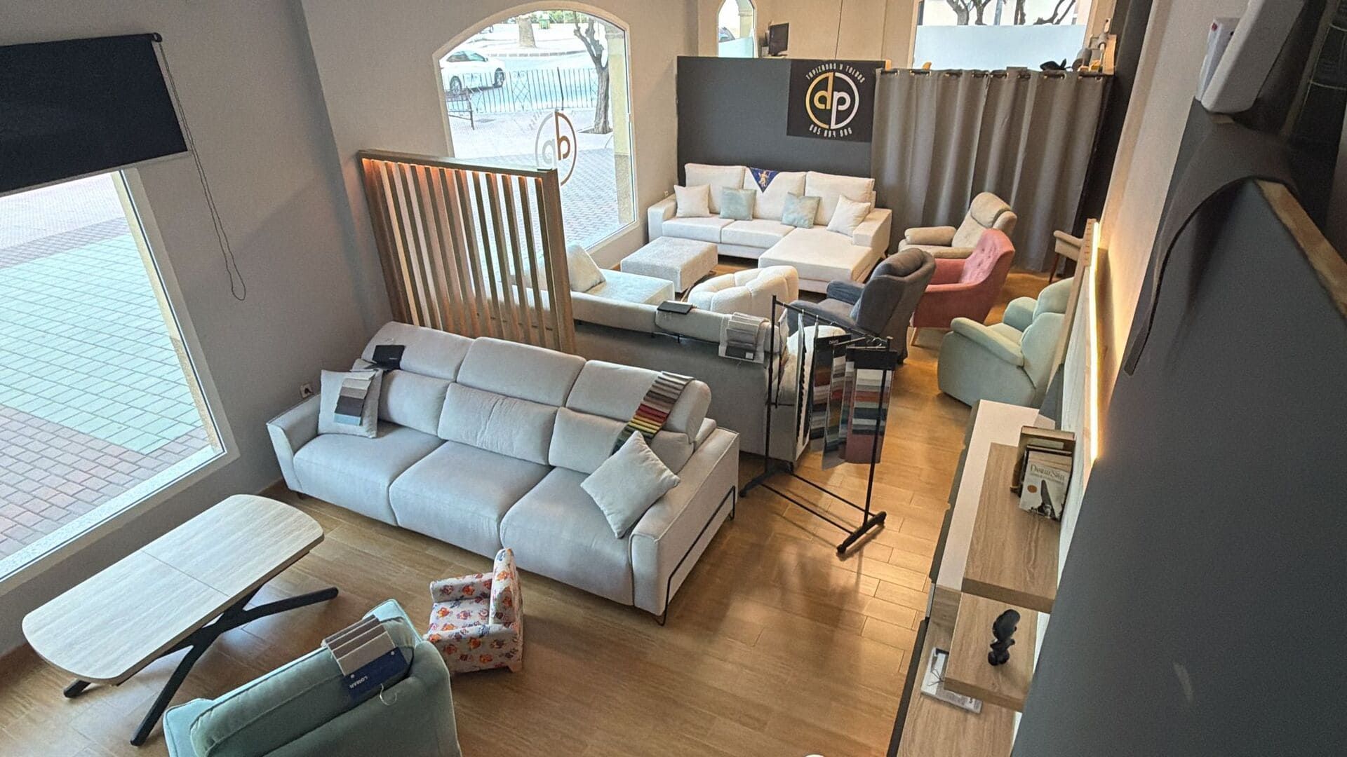 Exposición de muebles para salón. Sofás, sillas, mesas y detalles de madera en un espacio luminoso.