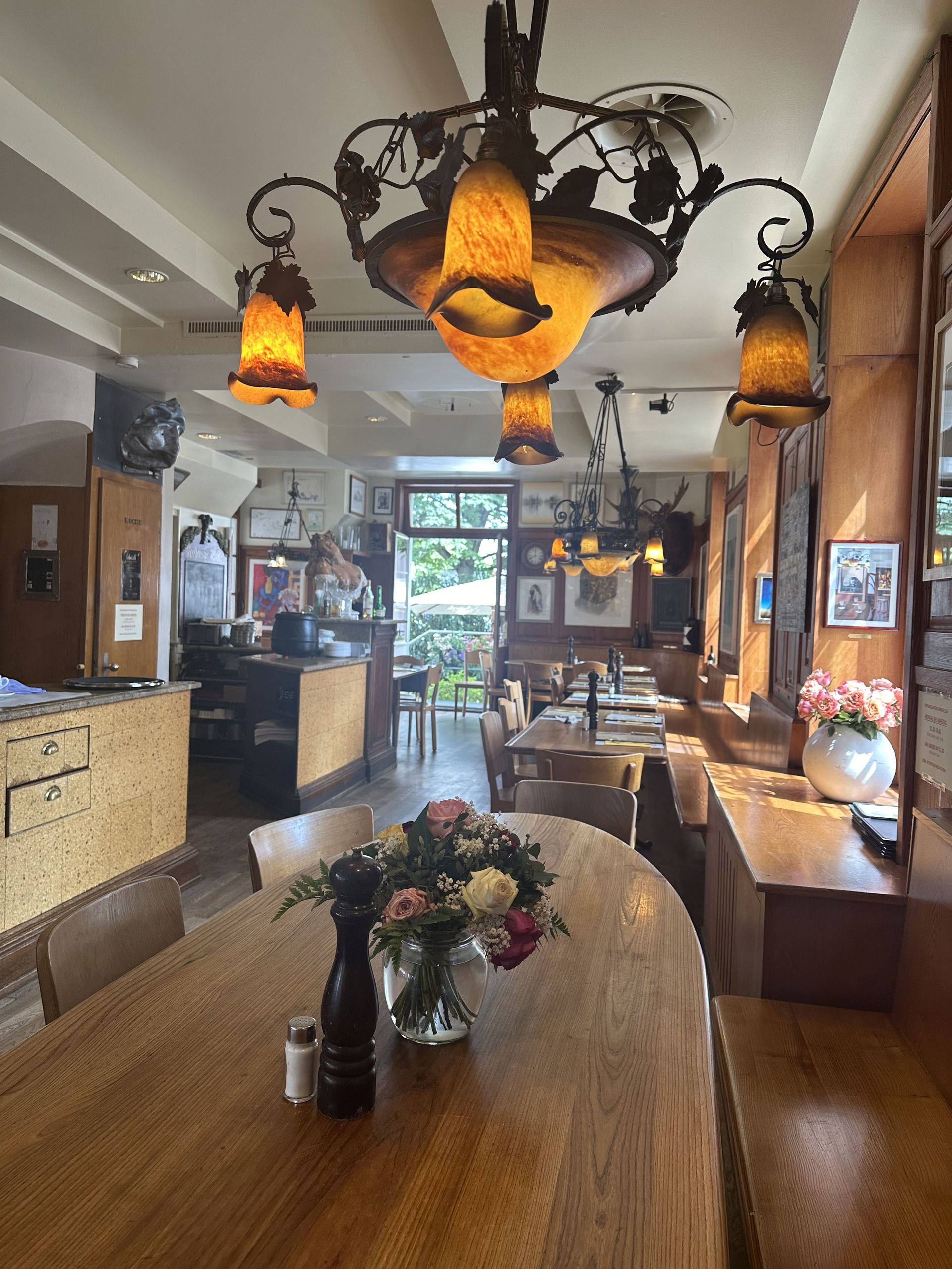 Ein Restaurant mit Tischen und Stühlen und einer Vase mit Blumen auf dem Tisch