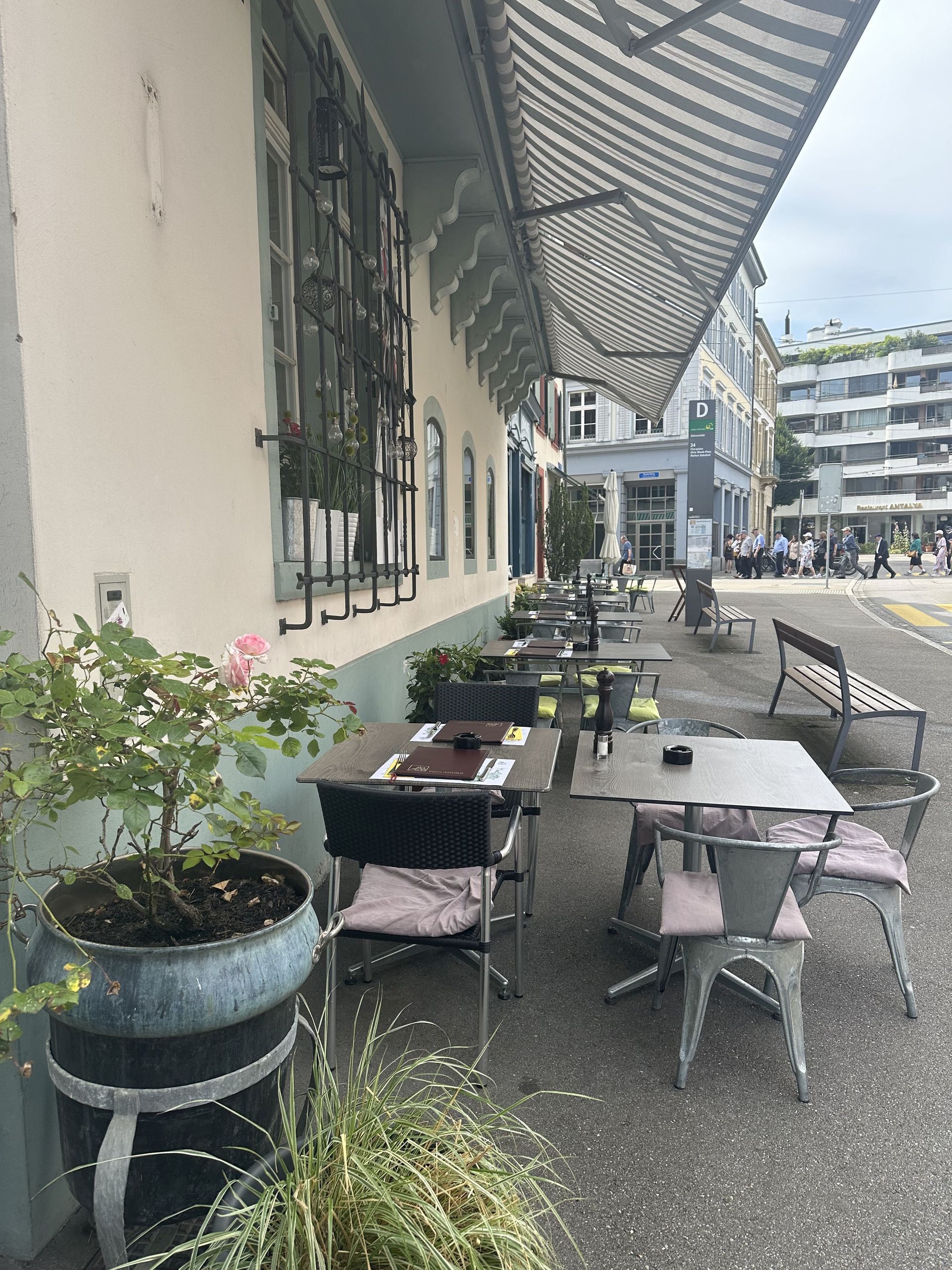 Eine Reihe von Tischen und Stühlen vor einem Gebäude.