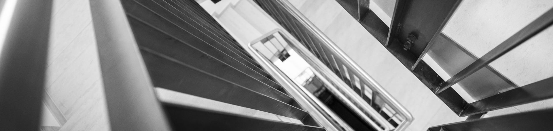 Schwarz-Weiß Aufnahme eines Treppenhauses von oben herab