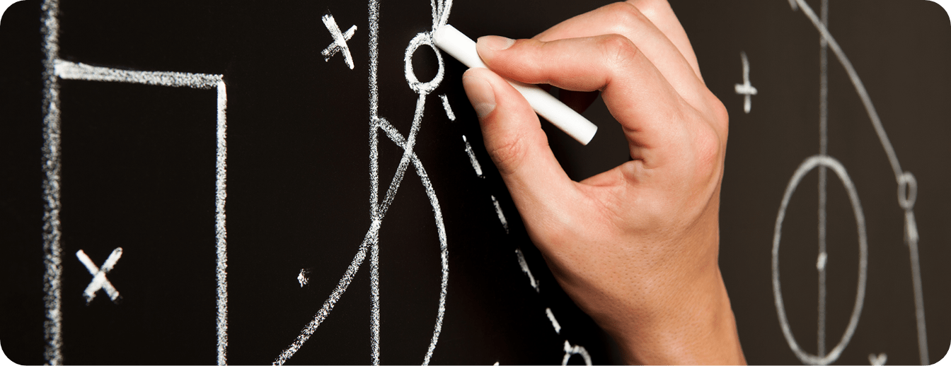 A person is writing on a blackboard with chalk