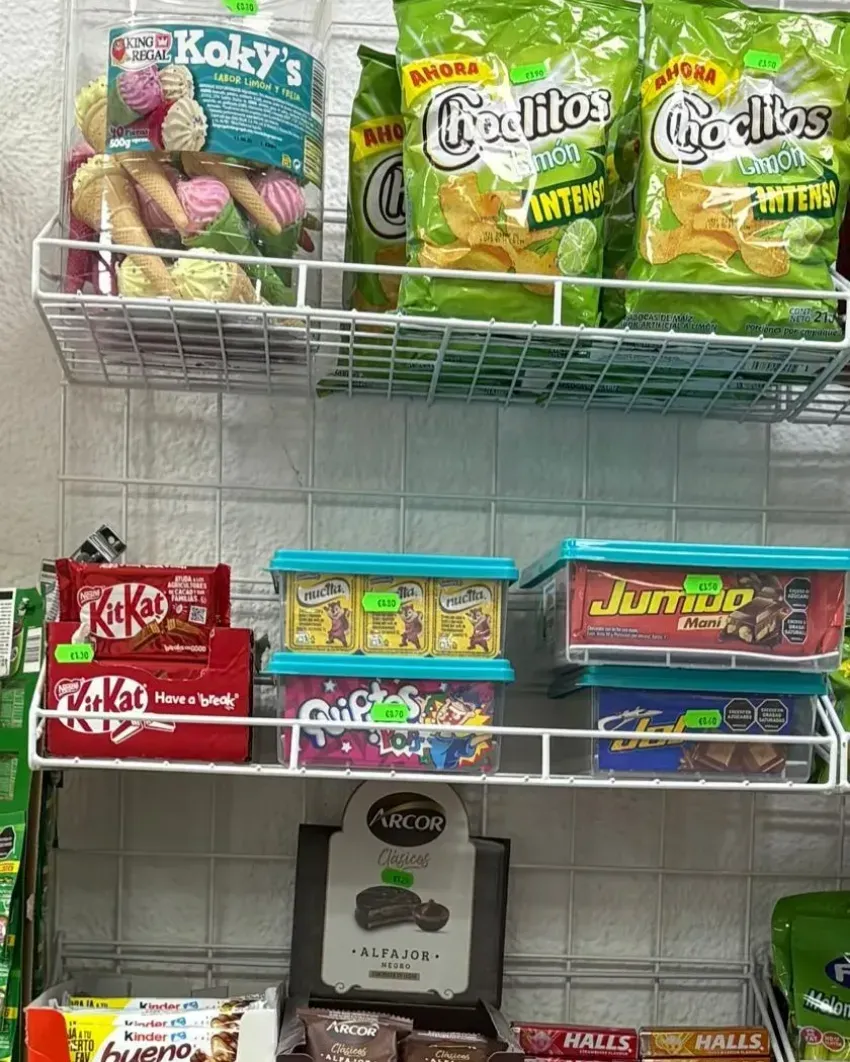 Estanterías expositoras de dulces y aperitivos con coloridos paquetes en un pasillo de la tienda.