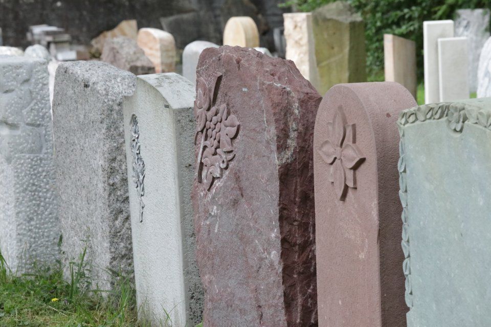 Grabmale auf einem Friedhof mit unterschiedlichen Ornamenten