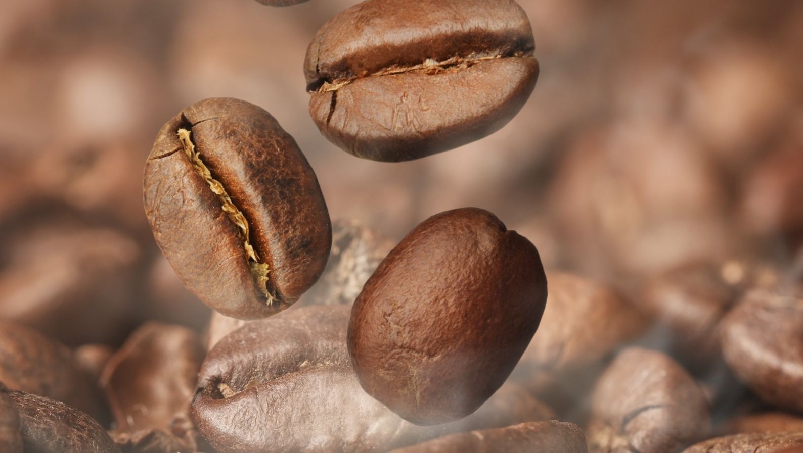 Los granos de café están cayendo en una pila de granos de café.