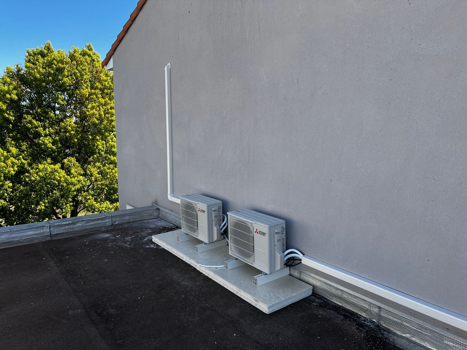 Pompe à chaleur installée au sol contre une maison