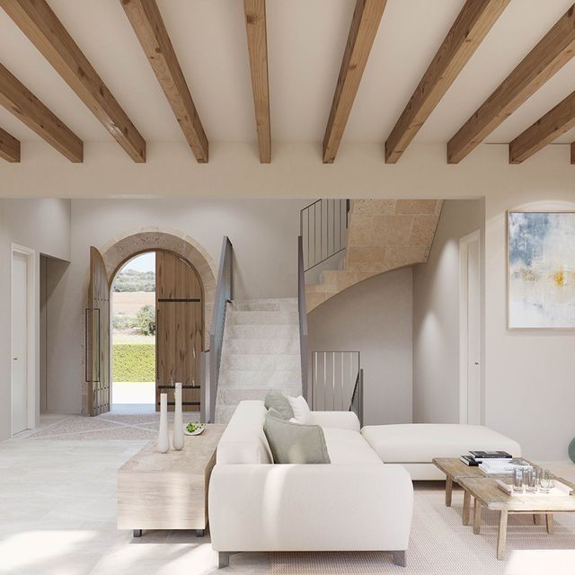Una sala de estar con un sofá blanco y vigas de madera.