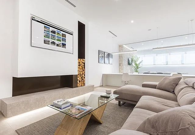 Una sala de estar con sofá, mesa de café, televisión y chimenea.