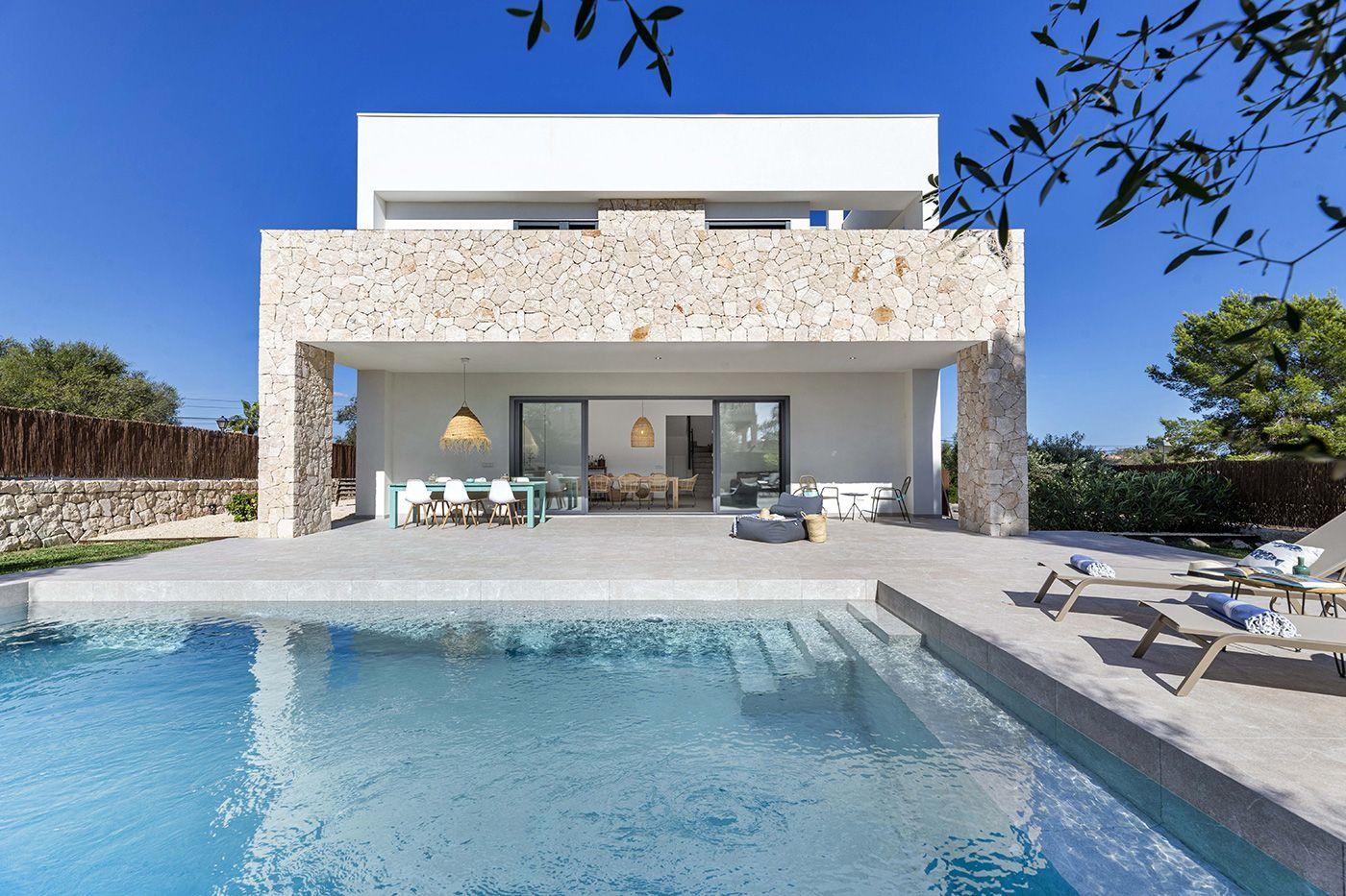 Una gran casa blanca con una piscina delante de ella.