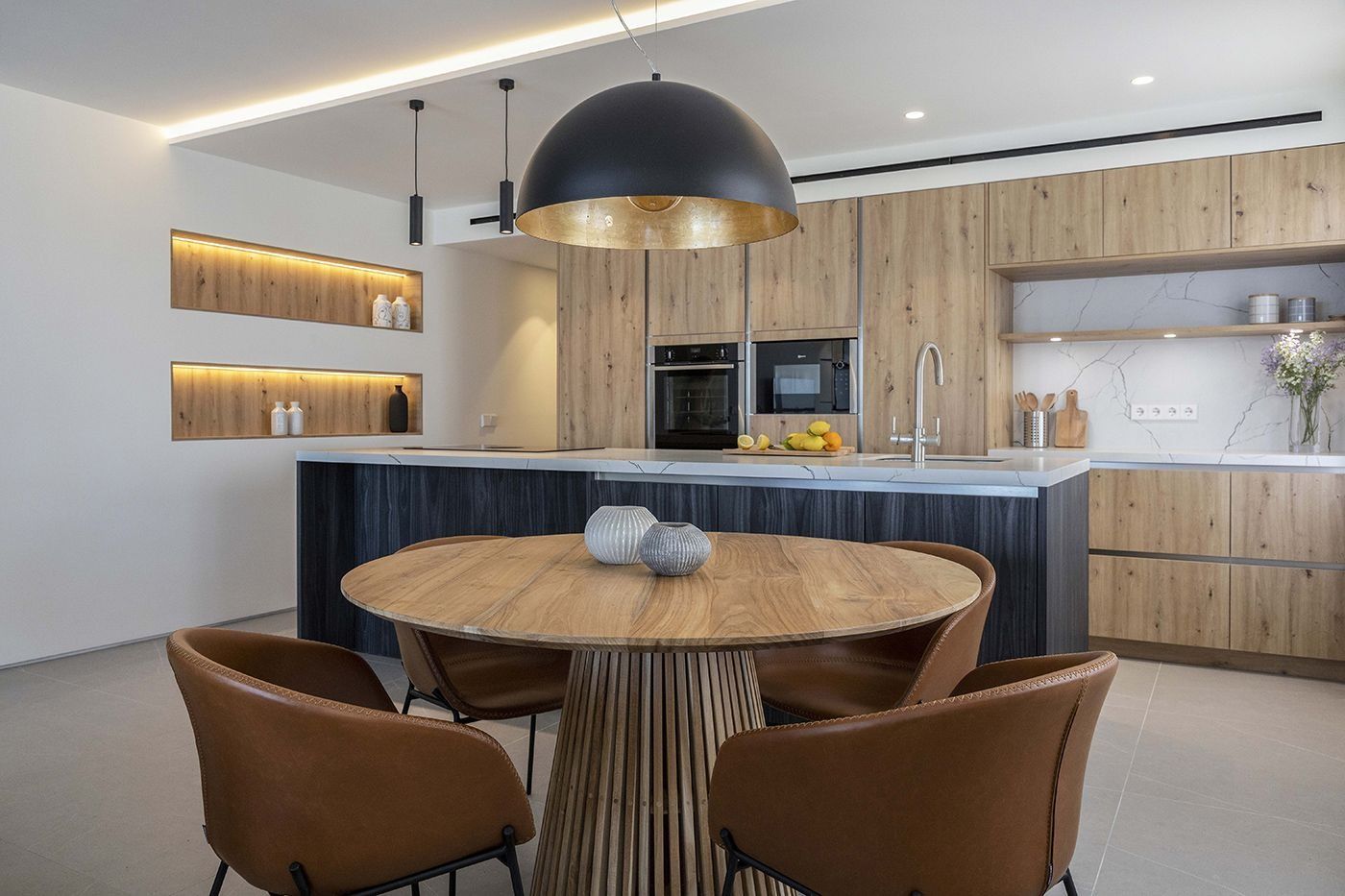 Una cocina con una mesa redonda y sillas.